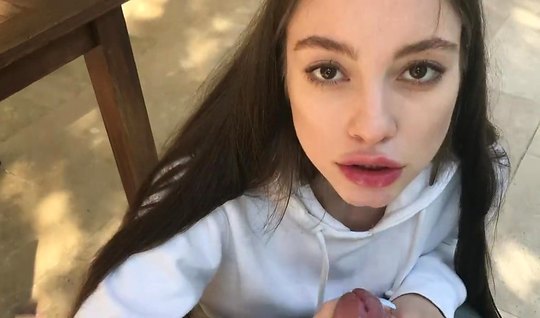 Long-haired brunette on her knees makes a Blowjob to the guy on camera